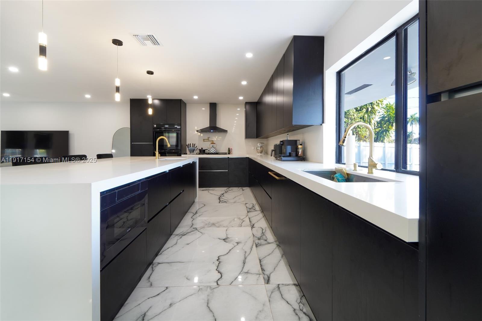 1850 Northeast 199th Street Miami, FL 33179 - Photo 3 of 29 a large white kitchen with a large window