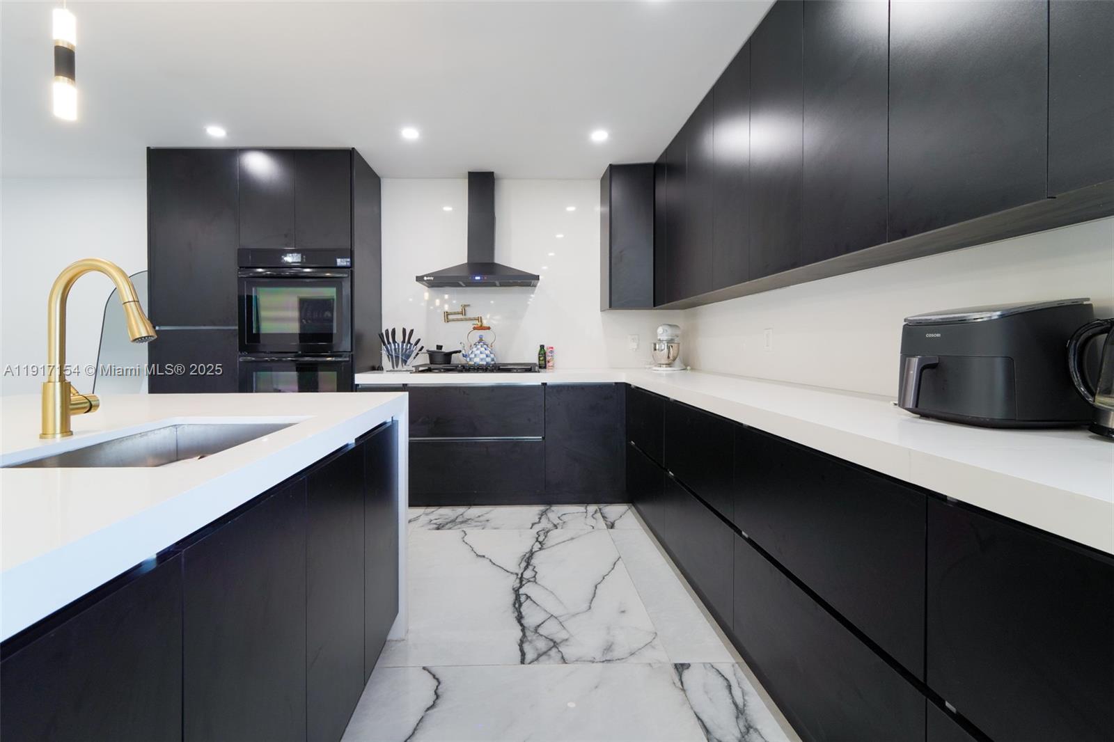 1850 Northeast 199th Street Miami, FL 33179 - Photo 5 of 29 a kitchen with stainless steel appliances a sink dishwasher a stove a refrigerator and cabinets with wooden floor