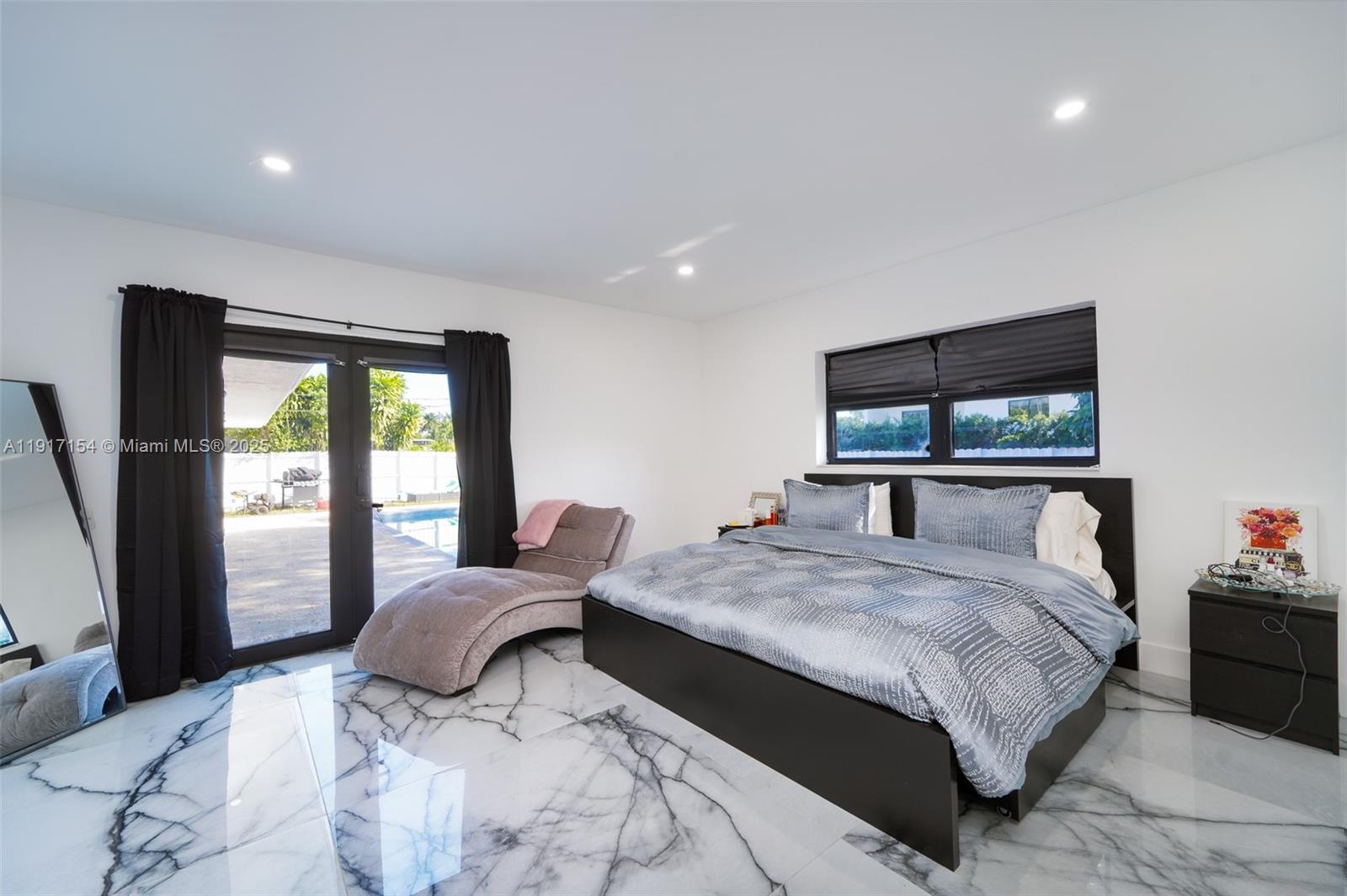 1850 Northeast 199th Street Miami, FL 33179 - Photo 10 of 29 a bedroom with a large bed and a flat tv screen on dresser