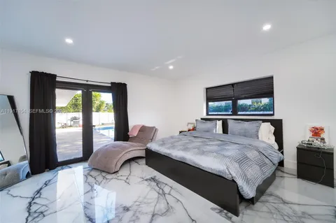 a bedroom with a large bed and a flat tv screen on dresser