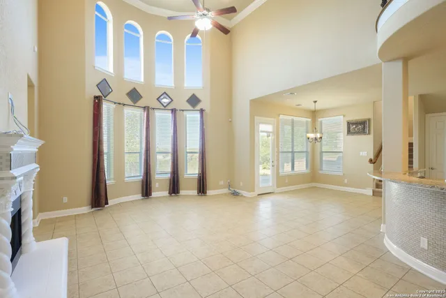 a view of an empty room with a fireplace and a chandelier