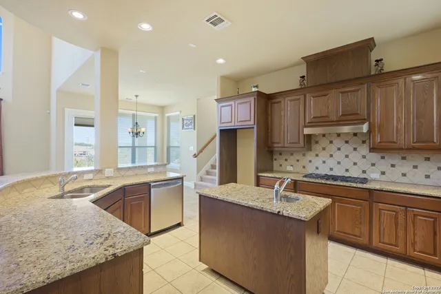 a kitchen with stainless steel appliances granite countertop a sink stove and cabinets