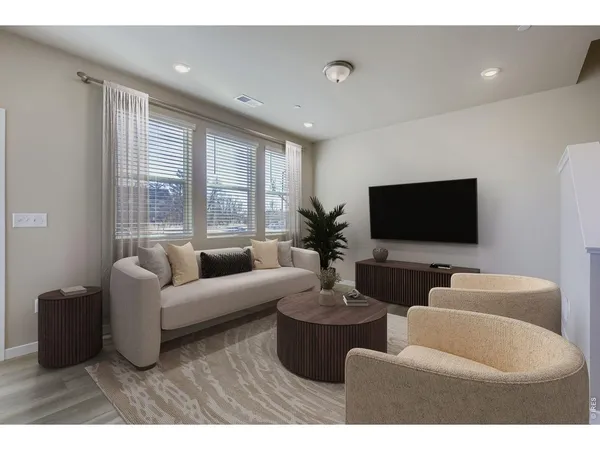 a living room with furniture a fireplace and a kitchen view