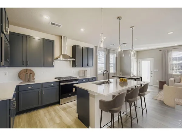 a kitchen with kitchen island a sink dining table and chairs