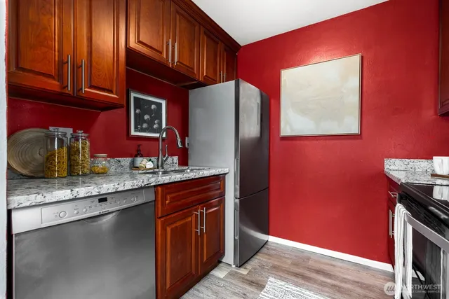 a kitchen with stainless steel appliances granite countertop a sink stove and wooden cabinets