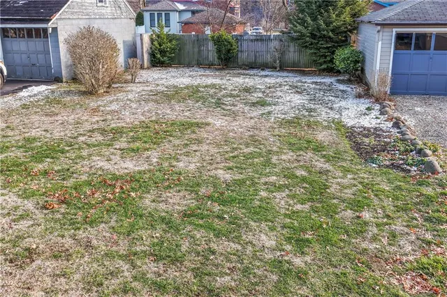 a view of a yard with plants and brick wall