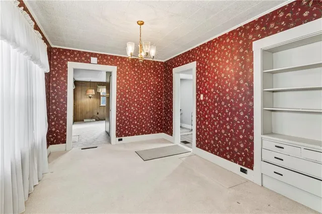 a view of a hallway with closet and a window