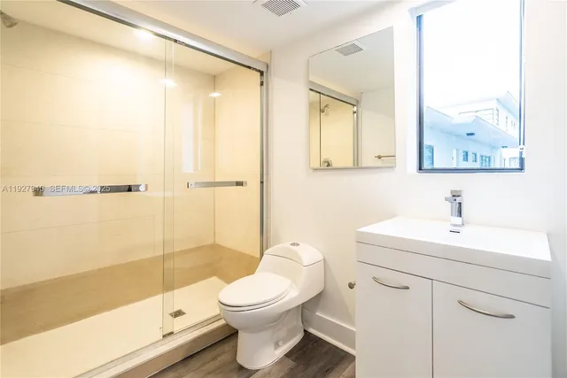 a bathroom with a sink a toilet and shower