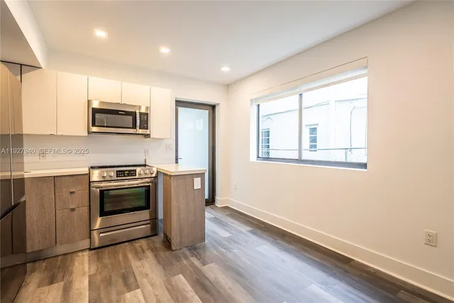 a kitchen with granite countertop a stove a sink and a microwave