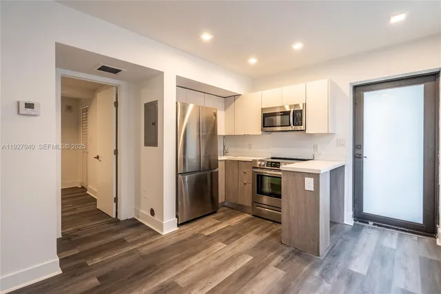 a kitchen with stainless steel appliances a refrigerator and a stove top oven