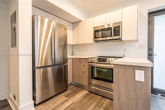 a kitchen with stainless steel appliances a refrigerator stove and microwave