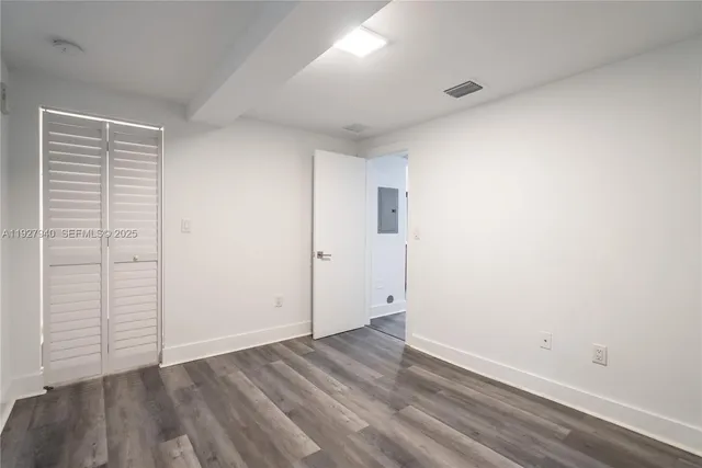an empty room with wooden floor and closet
