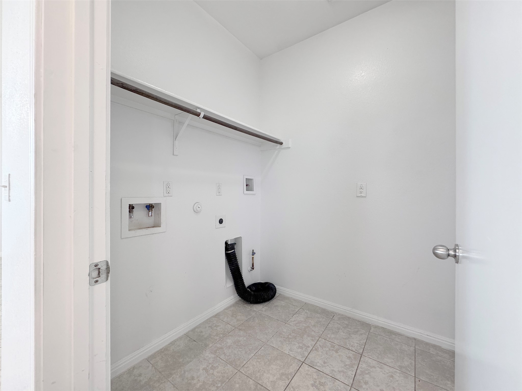 251 Triumph Road Buda, TX 78610 - Photo 11 of 24 Laundry area with gas dryer hookup, hookup for a washing machine, electric dryer hookup, and light tile patterned floors