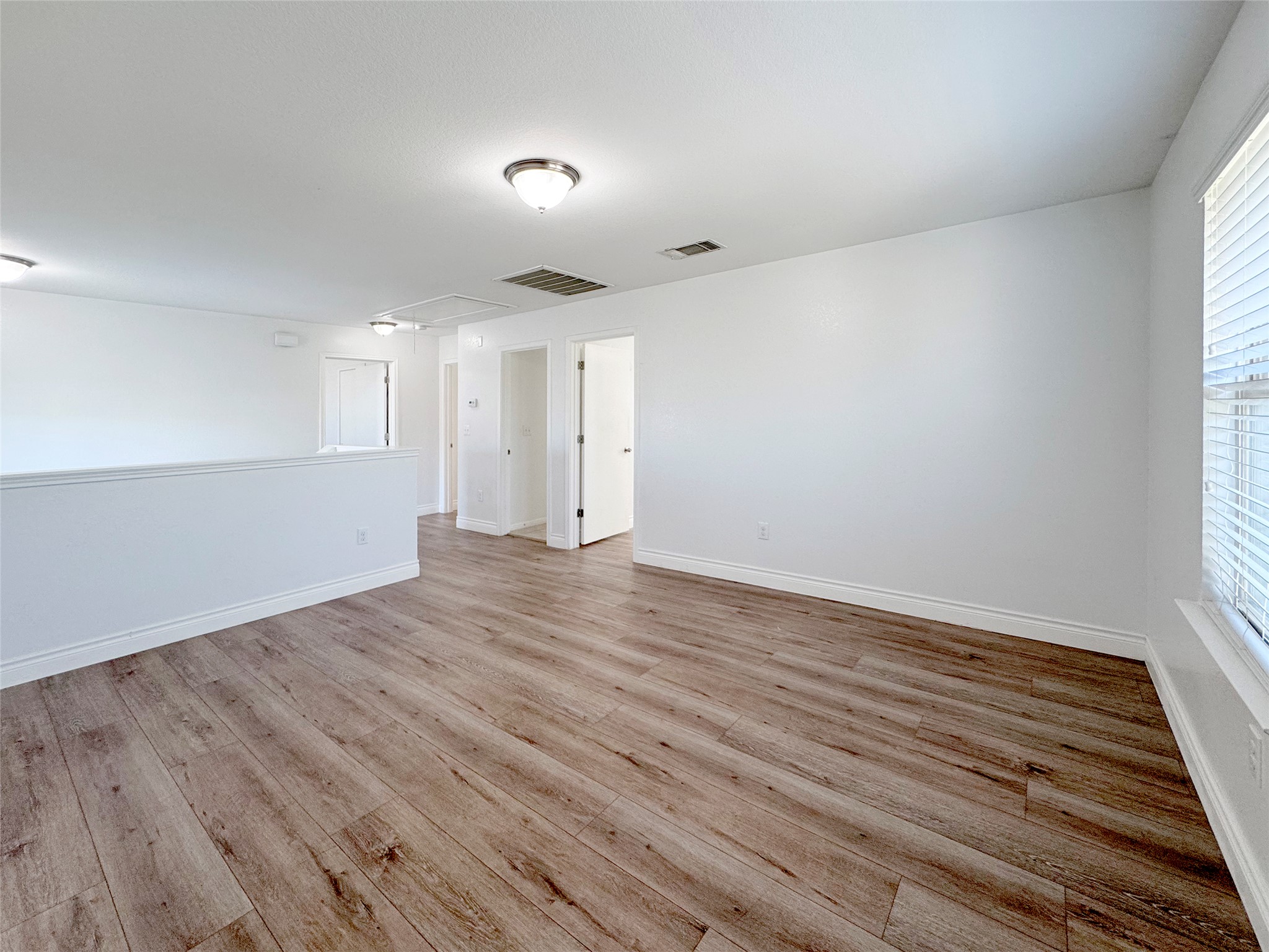 251 Triumph Road Buda, TX 78610 - Photo 14 of 24 Empty room with light wood finished floors and baseboards
