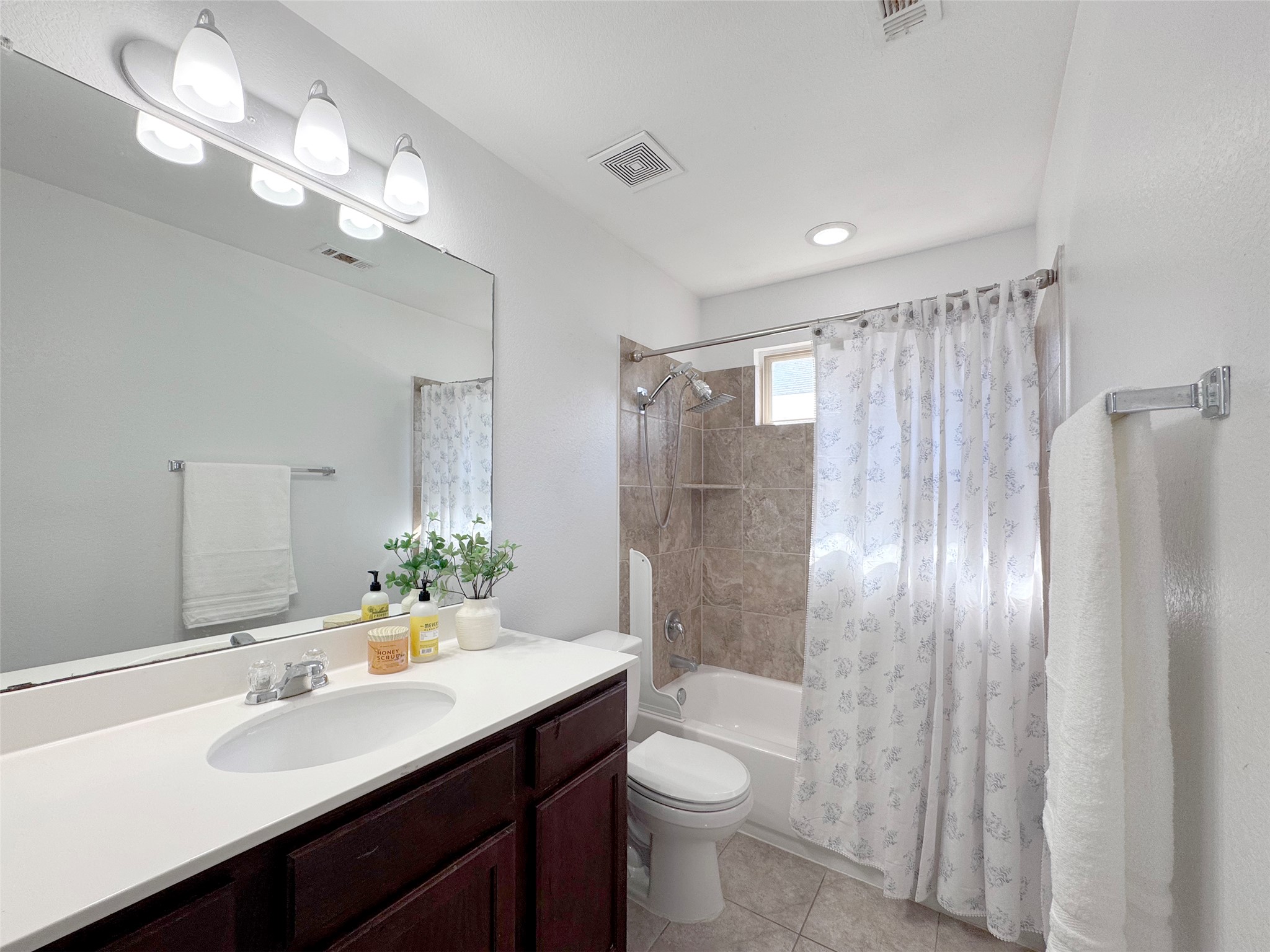 251 Triumph Road Buda, TX 78610 - Photo 17 of 24 Full bath with vanity, shower / tub combo with curtain, and light tile patterned flooring