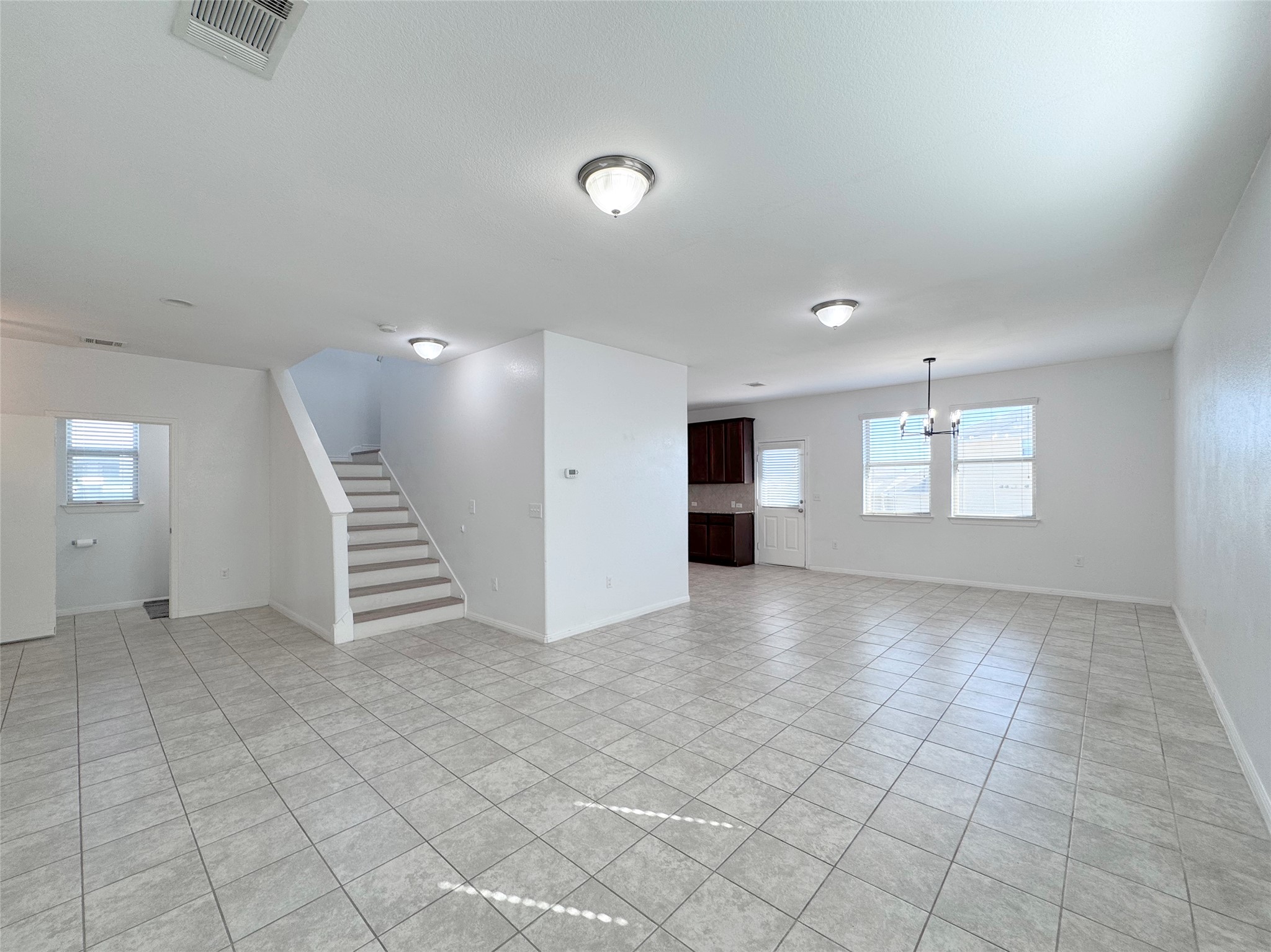 251 Triumph Road Buda, TX 78610 - Photo 7 of 24 Spare room with light tile patterned flooring and a chandelier