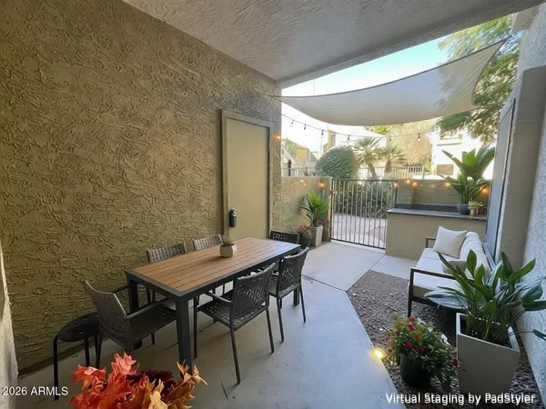 a patio with table and chairs and potted plants