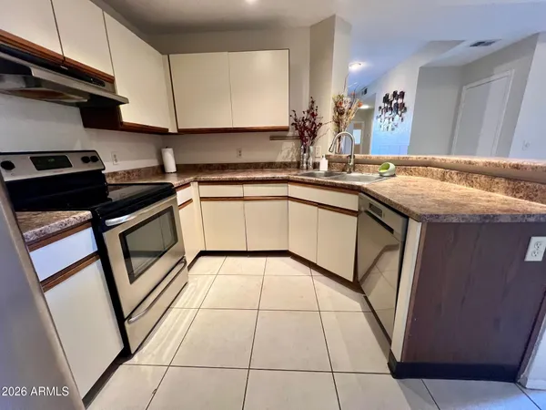 a kitchen that has a sink a table and chairs in it