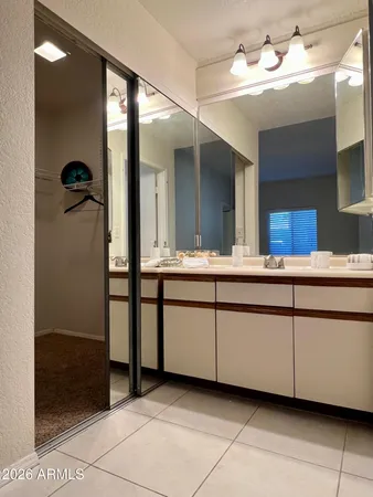 a bedroom with a bed and a mirror on dresser