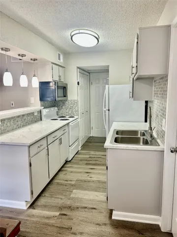 a kitchen with a sink stove and cabinets