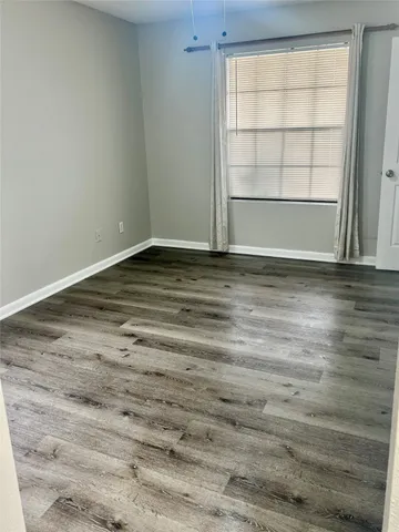 a view of a room with wooden floor and a window