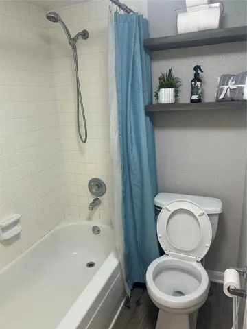 a white toilet sitting next to a bath tub and a sink