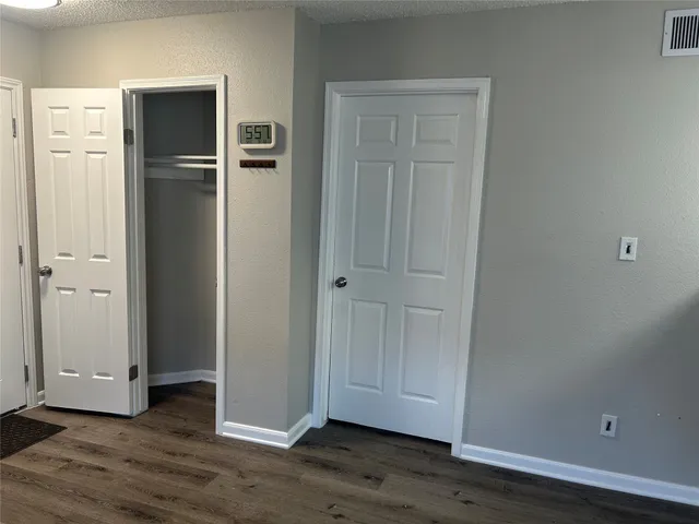 an empty room with wooden floor and closet