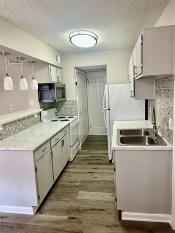 a kitchen with a sink stove and refrigerator