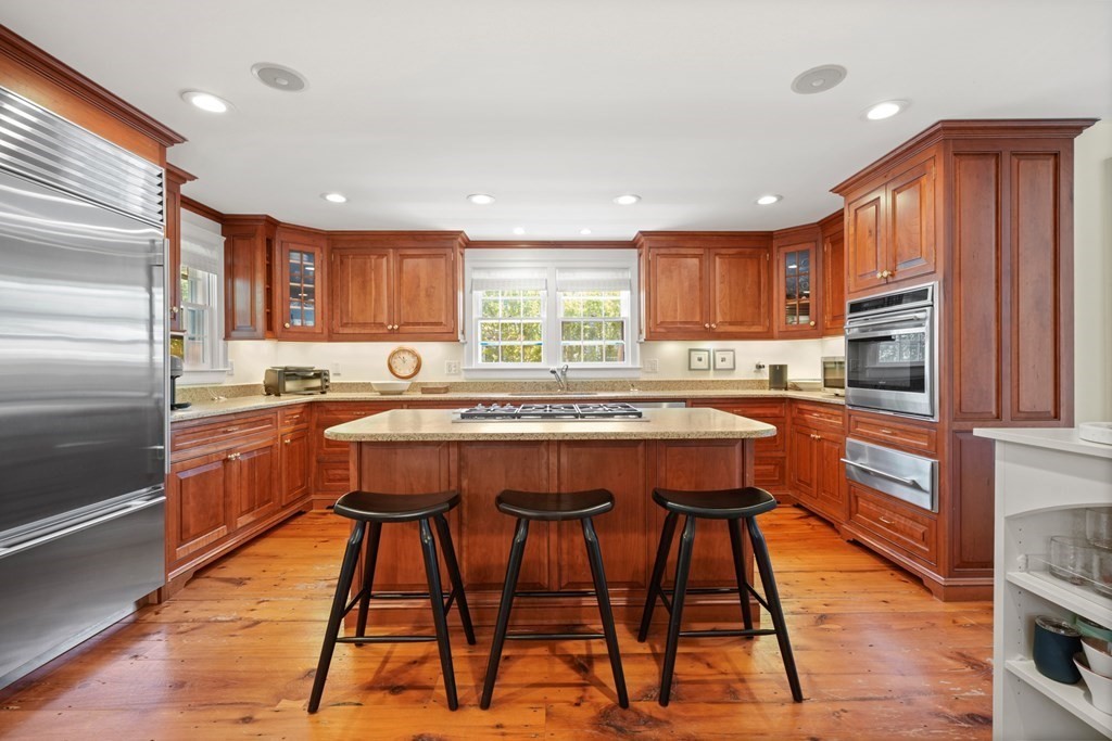 39 Milk Street Nantucket, MA 02554 - Photo 8 of 22 a kitchen with stainless steel appliances granite countertop a refrigerator a sink dishwasher a stove and white countertops with wooden floor