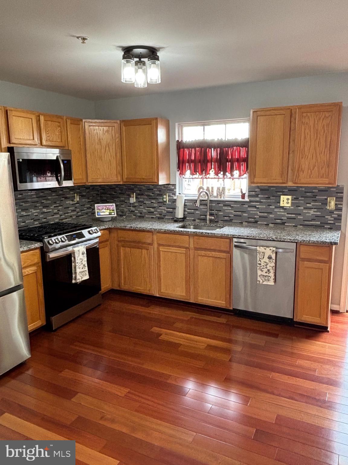 3910 Squire Tuck Way Baltimore, MD 21208 - Photo 7 of 40 a kitchen with stainless steel appliances granite countertop a stove a sink and a wooden floors