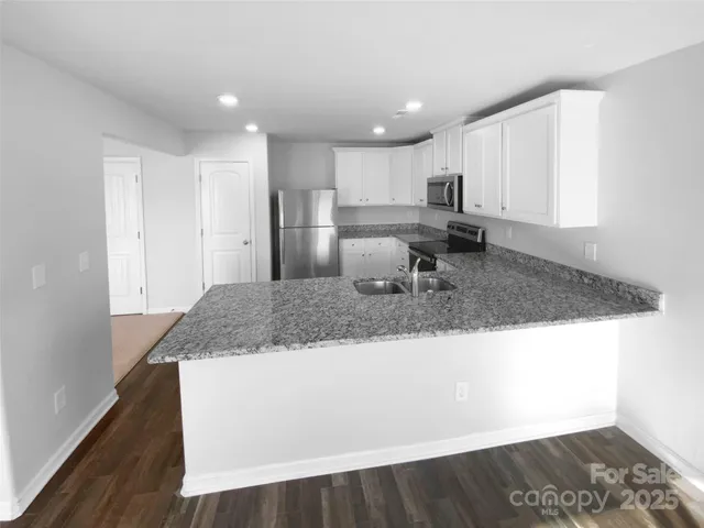 a large white bed sitting in a room next to a window