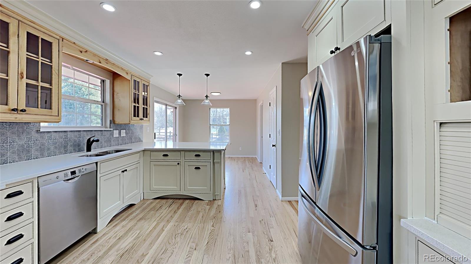 8774 Forrest Court Highlands Ranch, CO 80126 - Photo 11 of 31 a kitchen with stainless steel appliances granite countertop a refrigerator and a sink