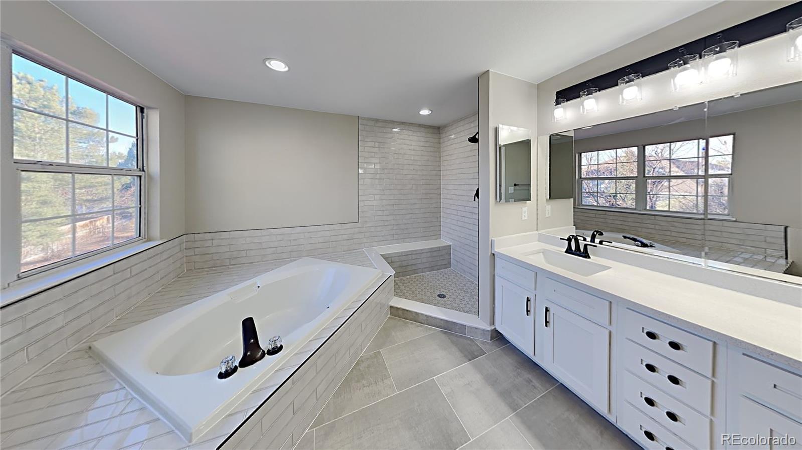 8774 Forrest Court Highlands Ranch, CO 80126 - Photo 18 of 31 a bathroom with a tub a sink double vanity and windows