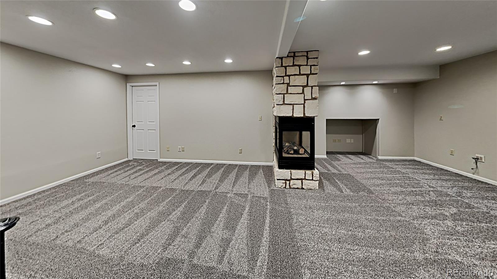 8774 Forrest Court Highlands Ranch, CO 80126 - Photo 5 of 31 a view of a livingroom with a flat screen tv wooden floor and staircase