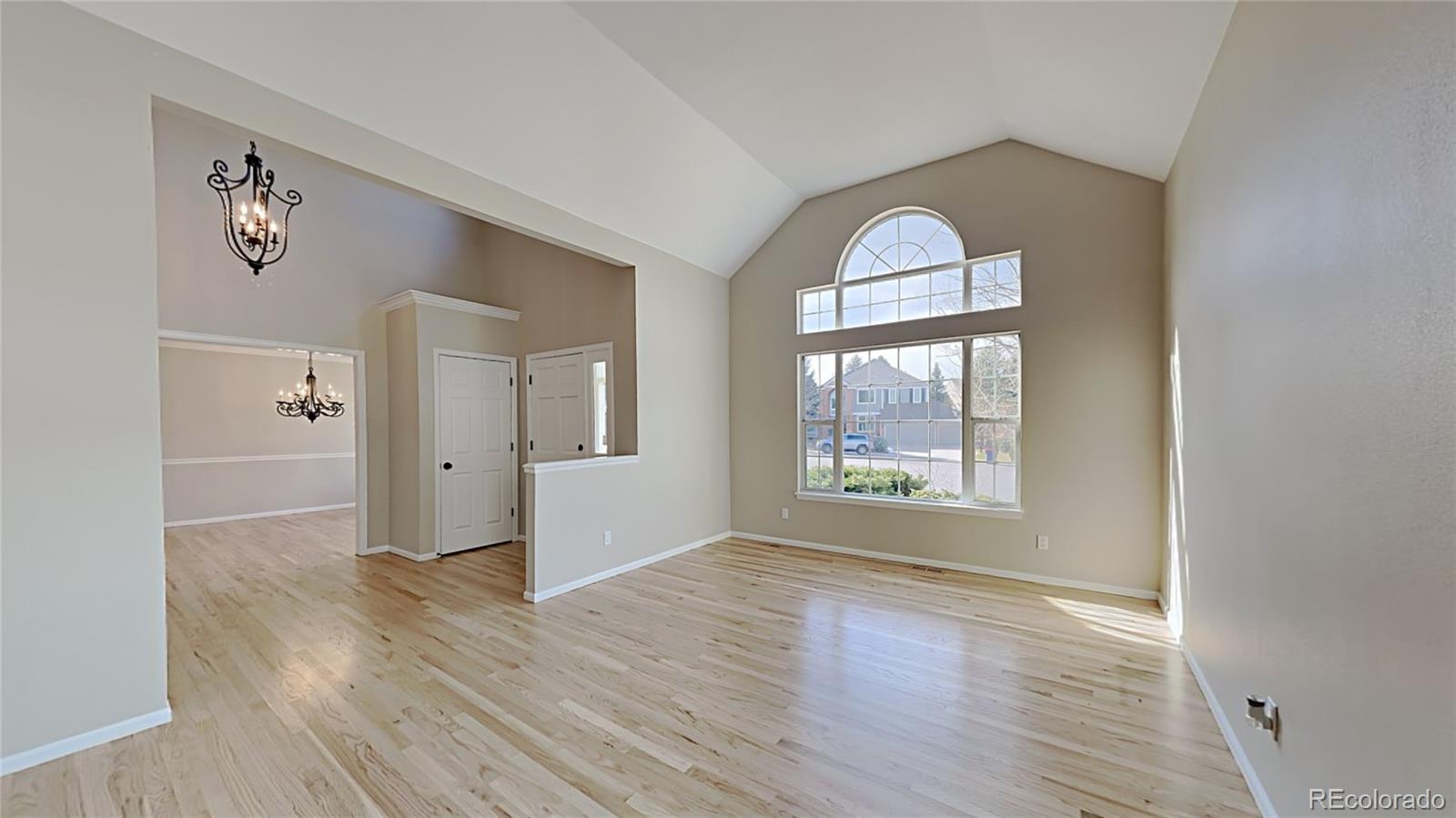 8774 Forrest Court Highlands Ranch, CO 80126 - Photo 6 of 31 an empty room with wooden floor mirror and windows
