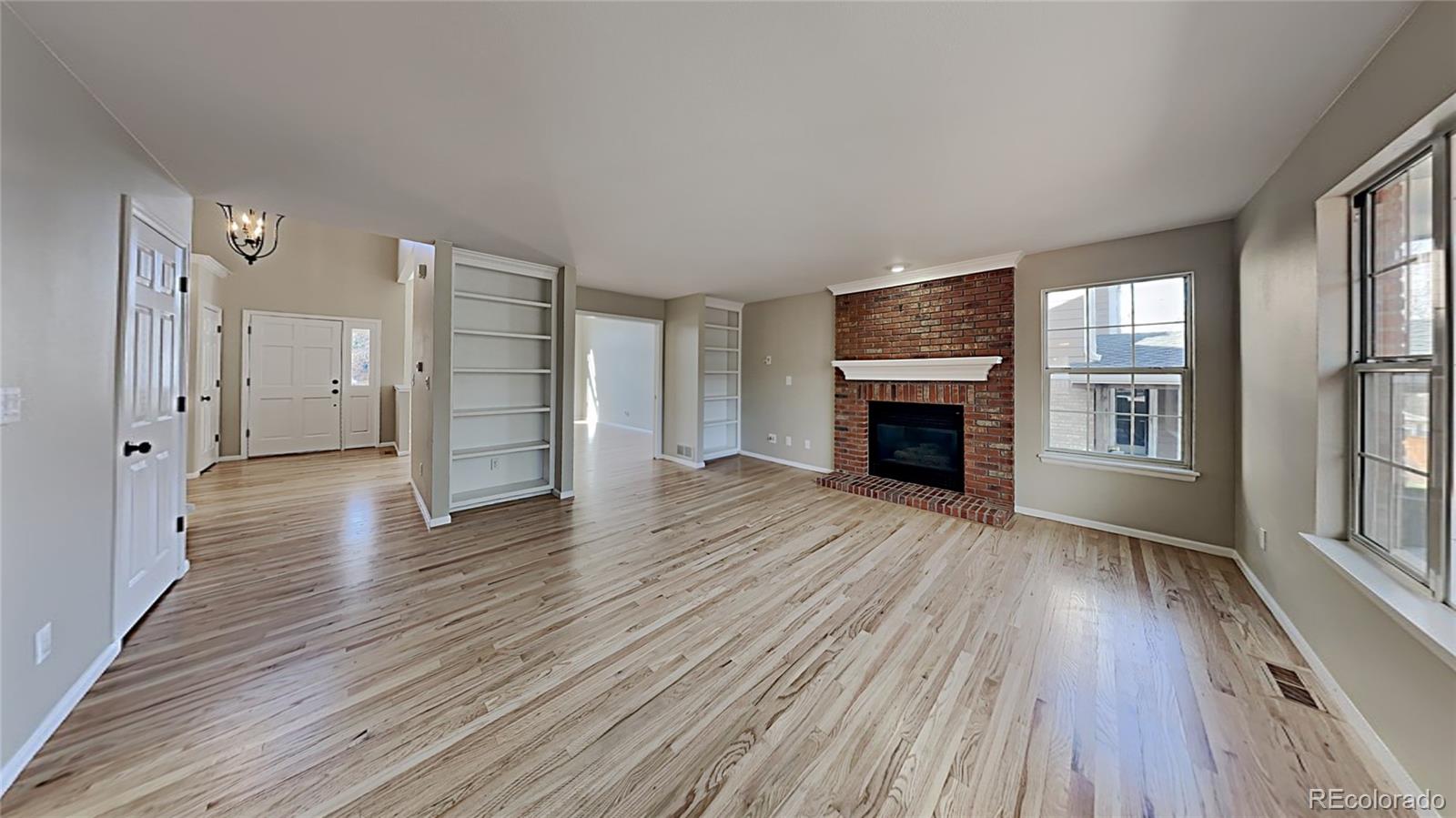 8774 Forrest Court Highlands Ranch, CO 80126 - Photo 8 of 31 wooden floor fireplace and windows in an empty room