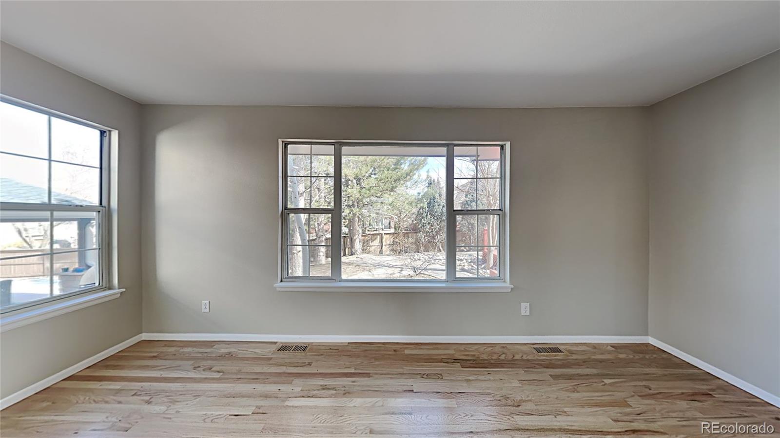 8774 Forrest Court Highlands Ranch, CO 80126 - Photo 9 of 31 a view of an empty room with wooden floor and a window