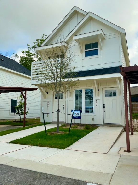 2002 West 2nd Street, Unit 602 Taylor, TX 76574 - Photo 1 of 13 a view of a white house with a yard and potted plants