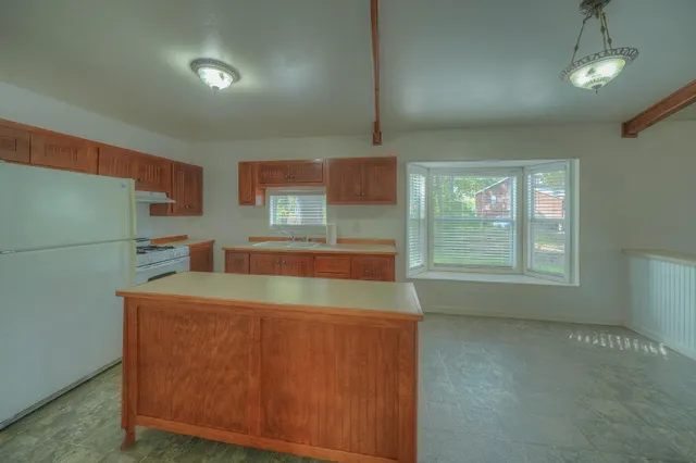 an empty room with a window and a ceiling fan