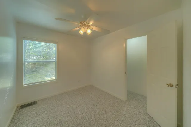 a view of a livingroom with furniture and chandelier fan