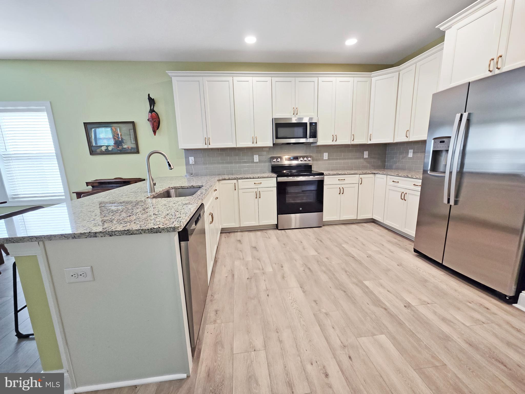 33768 Catching Cove Lewes, DE 19958 - Photo 2 of 69 a kitchen with granite countertop a refrigerator sink and white cabinets