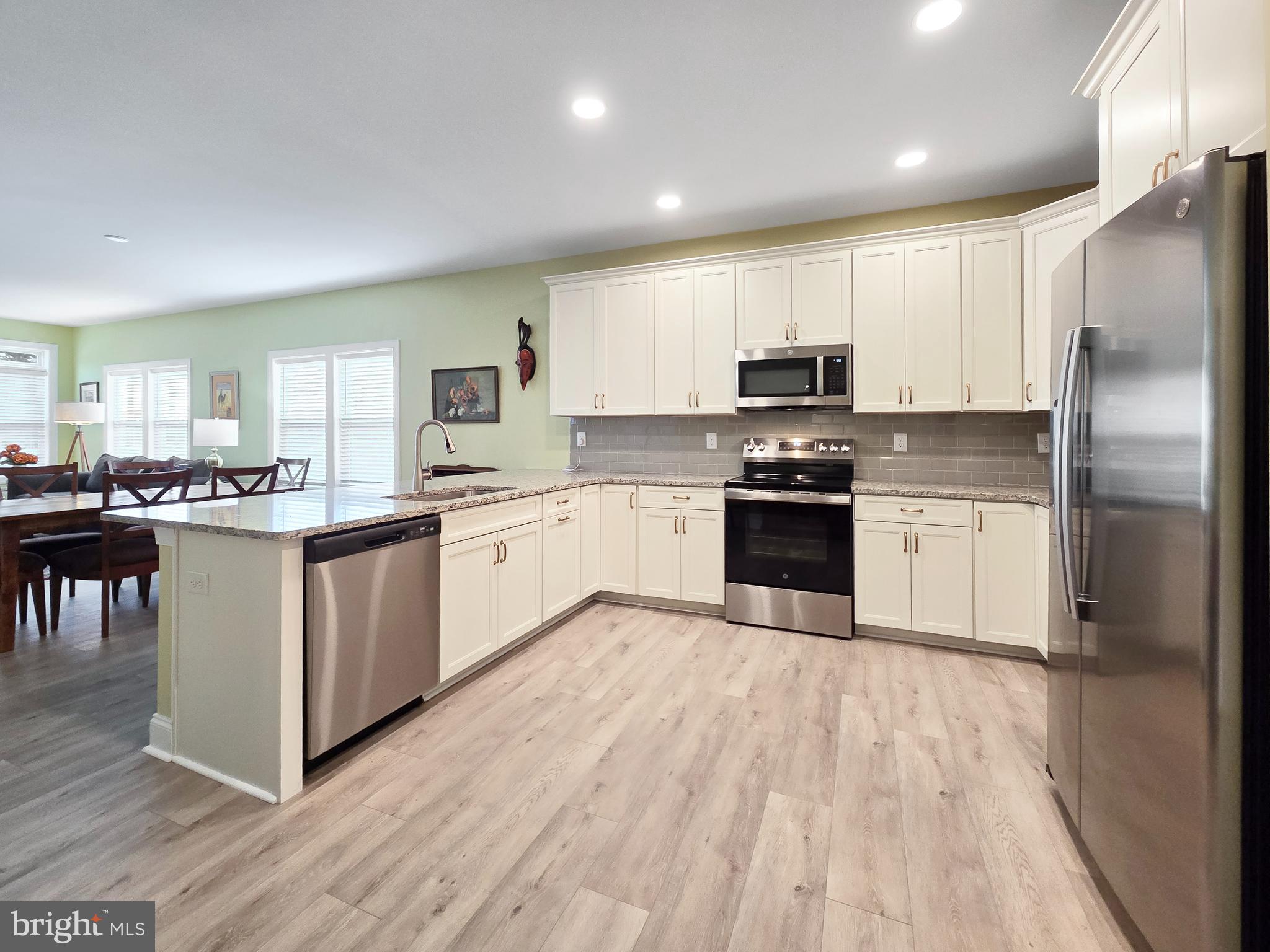33768 Catching Cove Lewes, DE 19958 - Photo 24 of 69 a kitchen with granite countertop a refrigerator and a stove top oven