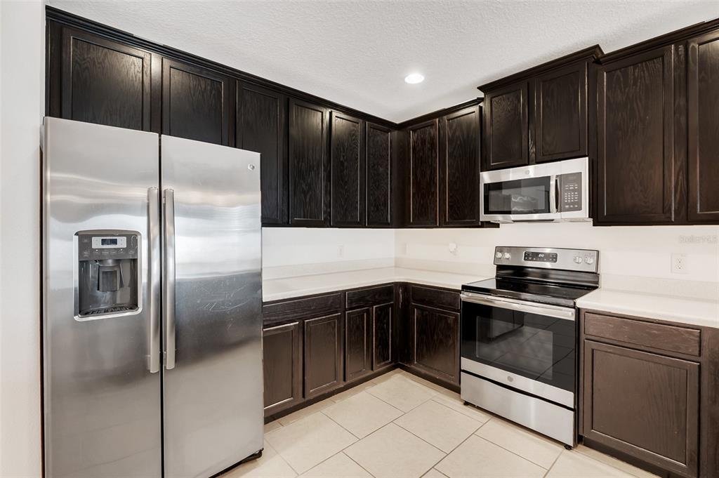 2620 Wadeview Loop St. Cloud, FL 34769 - Photo 12 of 38 a kitchen with a refrigerator sink and microwave