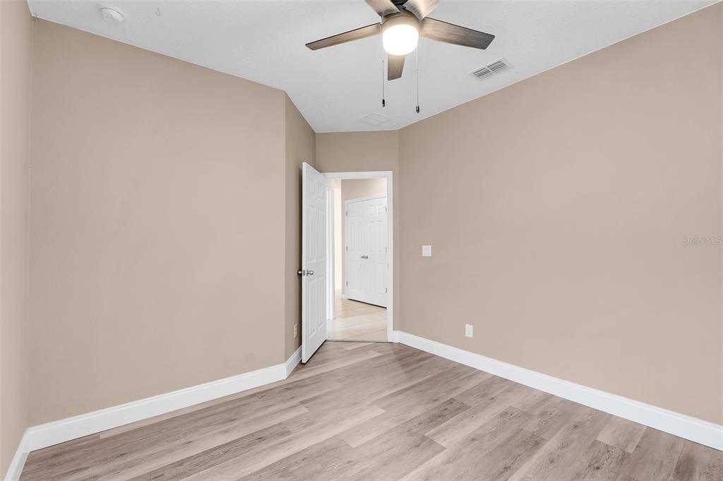 2620 Wadeview Loop St. Cloud, FL 34769 - Photo 25 of 38 an empty room with a ceiling fan and wooden floor