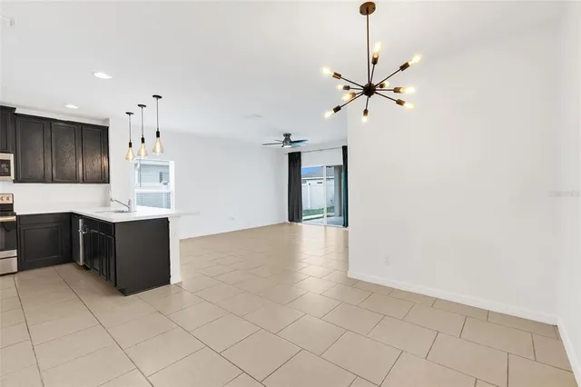 a large kitchen with stainless steel appliances kitchen island granite countertop a refrigerator and a sink