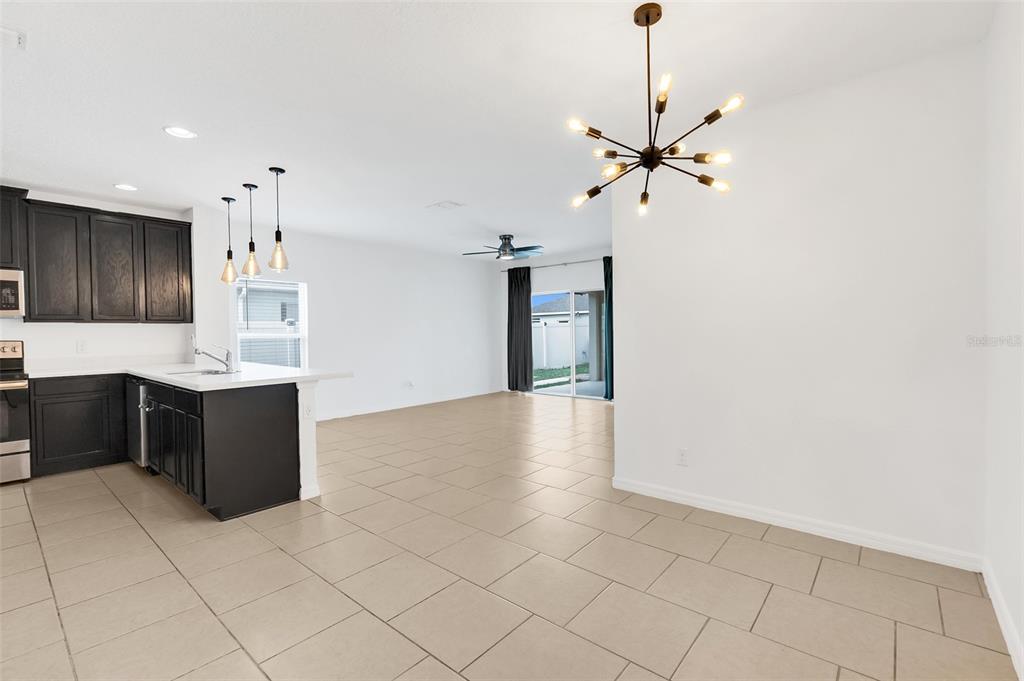 2620 Wadeview Loop St. Cloud, FL 34769 - Photo 9 of 38 a kitchen with kitchen island granite countertop a refrigerator a sink and dishwasher