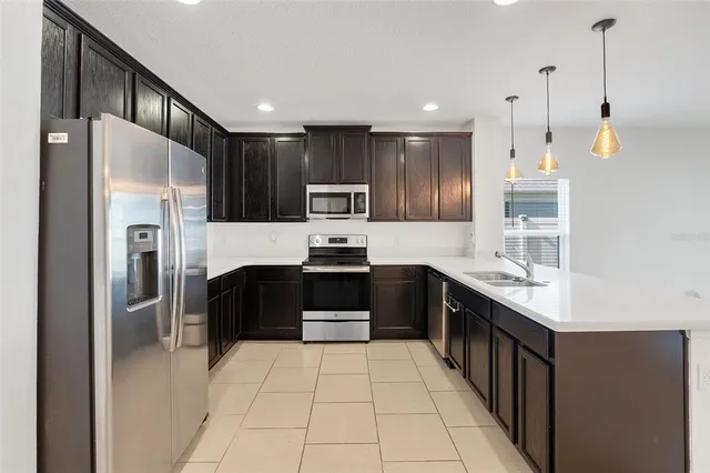 a kitchen with kitchen island granite countertop stainless steel appliances a stove sink and microwave