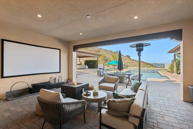 a view of a patio with a table chairs and a floor to ceiling window