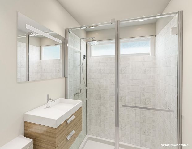 a bathroom with a sink mirror and a shower