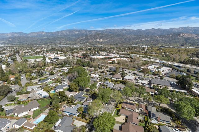 an aerial view of residential houses with outdoor space and trees